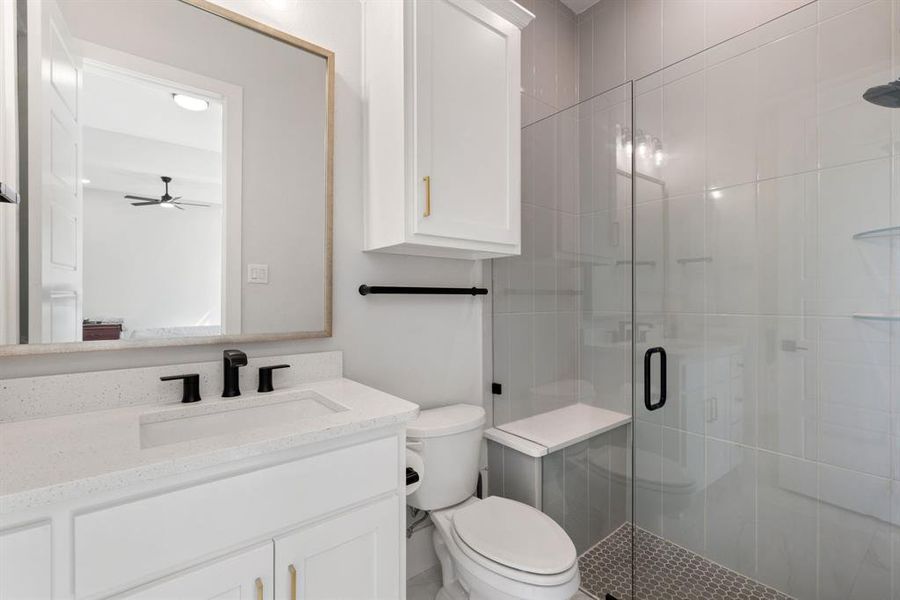 Full bathroom with a stall shower, vanity, and a ceiling fan