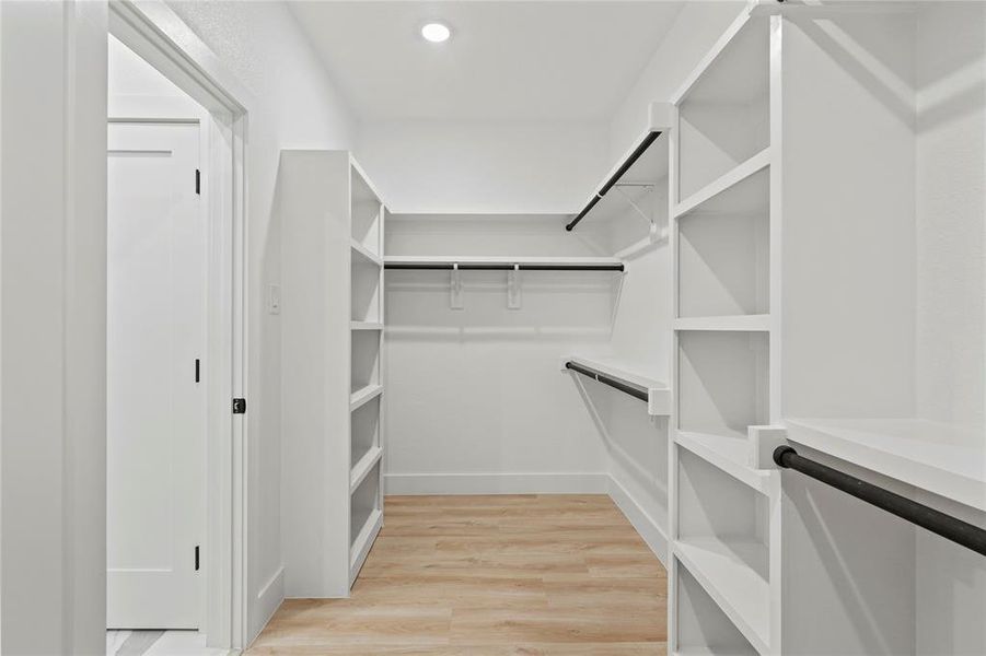 Walk in closet featuring light wood-style flooring Walk in closet featuring light wood-style flooring
