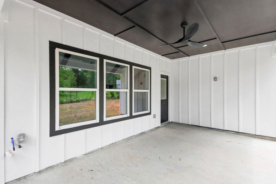 The perfect spot for relaxation or entertaining, this covered porch features a beautifully detailed ceiling, a modern cooling fan, and a solid concrete base The perfect spot for relaxation or entertaining, this covered porch features a beautifully detailed ceiling, a modern cooling fan, and a solid concrete base