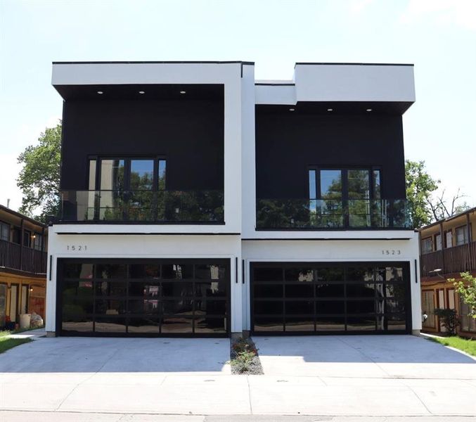 View of front of house featuring an attached garage, concrete driveway, and stucco siding