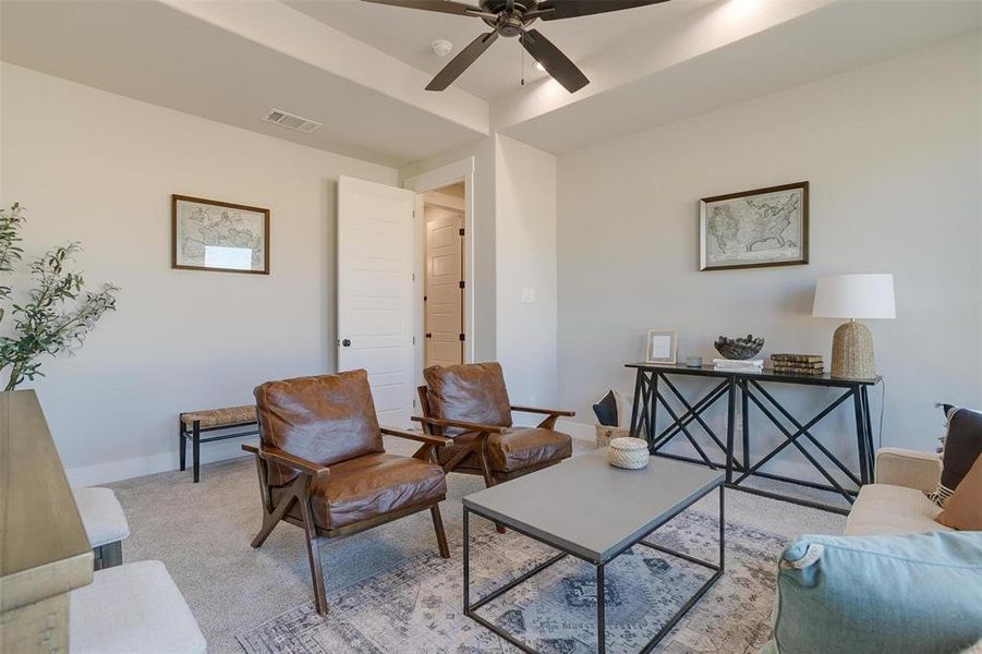 Living room with ceiling fan and light colored carpet