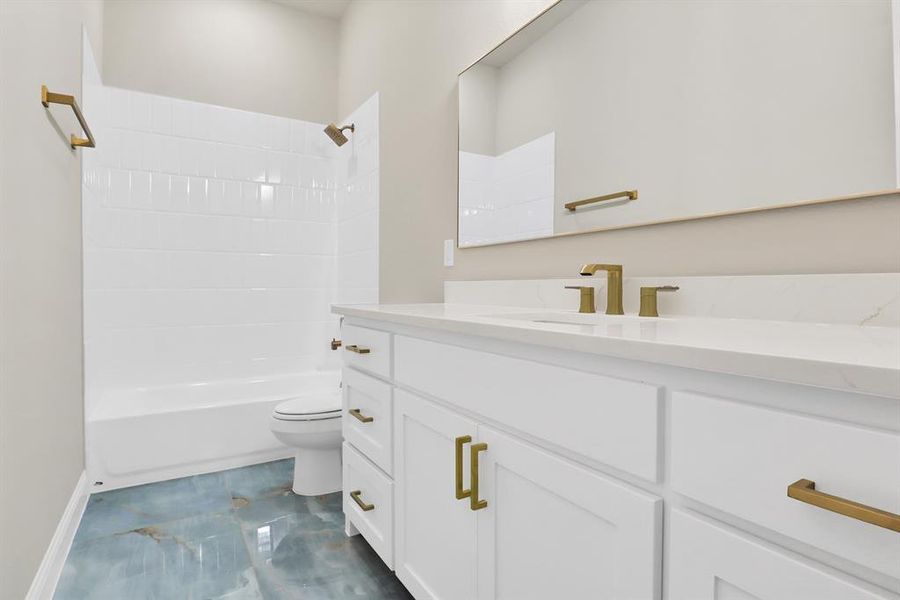 Full bathroom featuring tiled shower / bath, vanity, and toilet