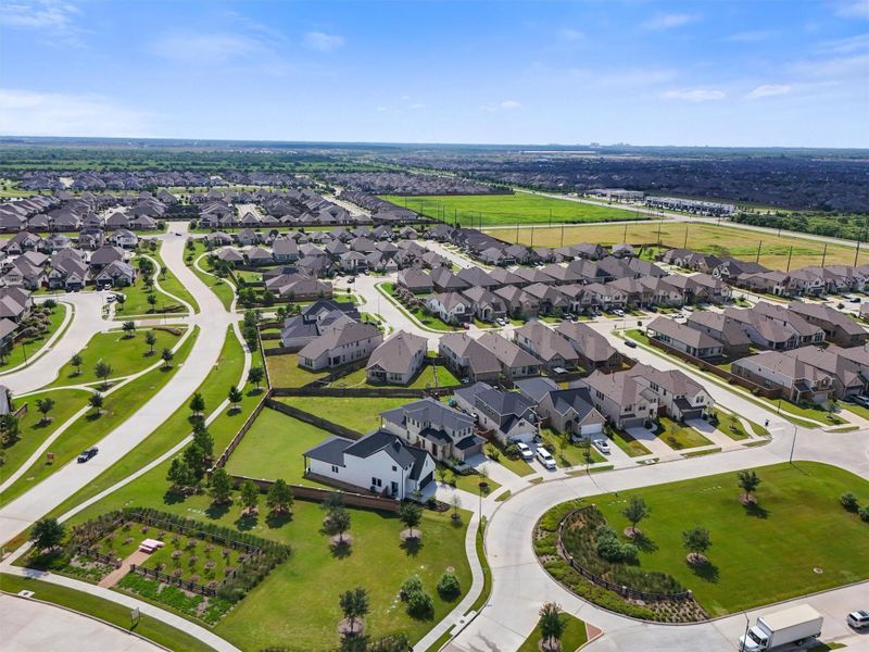 This aerial view shows the home's prime location within Elyson, highlighting its easy access to the community's main entrance. The home is positioned close to green spaces and walking paths, offering a seamless blend of suburban living and nature.