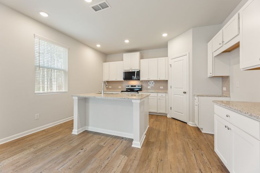 A kitchen with white cabinets.