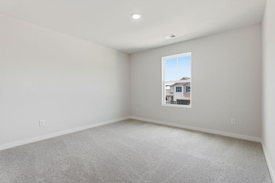 A room with a window and a carpet.