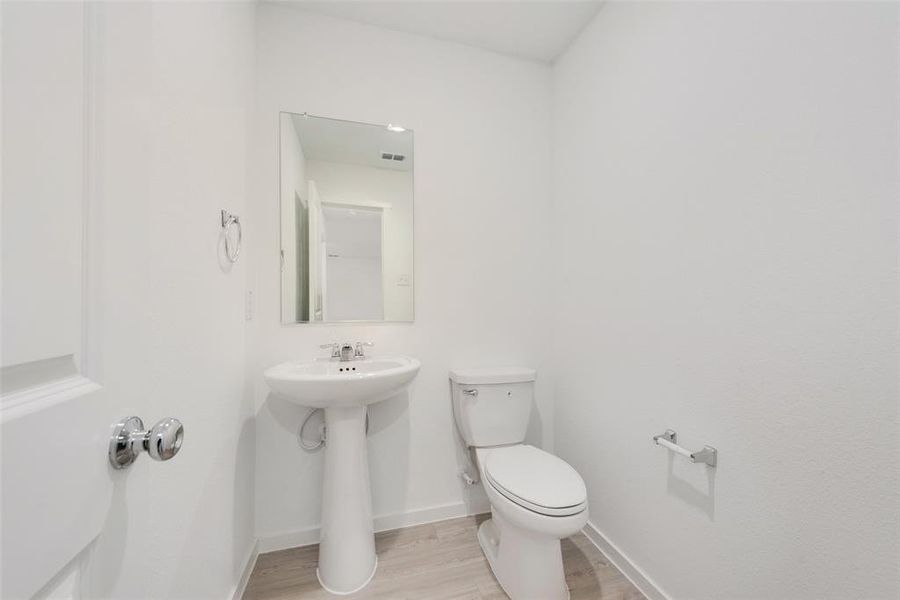 Bathroom with hardwood / wood-style flooring, toilet, and sink