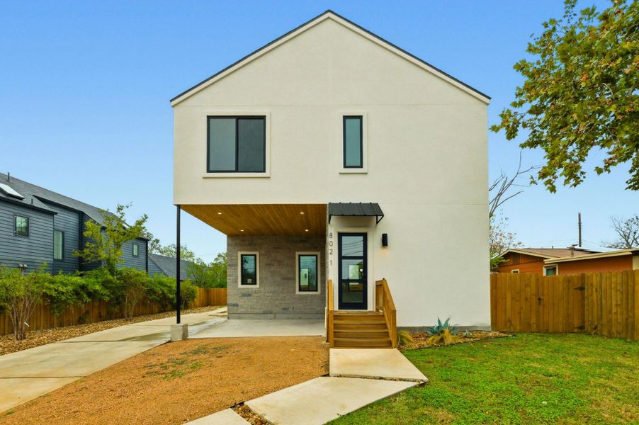 View of front of property with a fenced backyard and stucco siding
