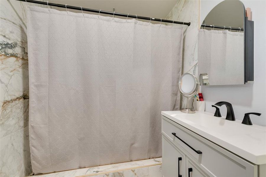 Bathroom featuring vanity and marble finish floor