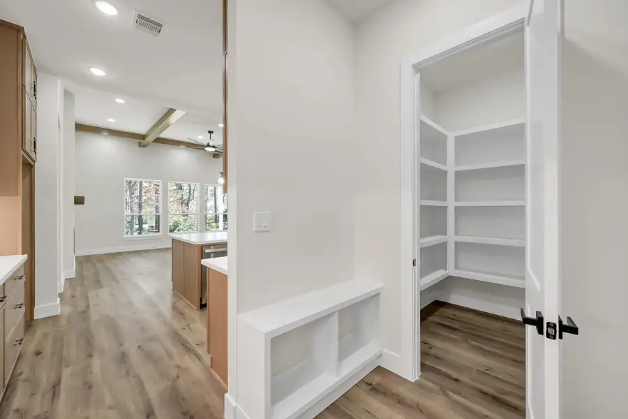Large walk in pantry and mud area is neatly hidden right off the kitchen leading to the garage.