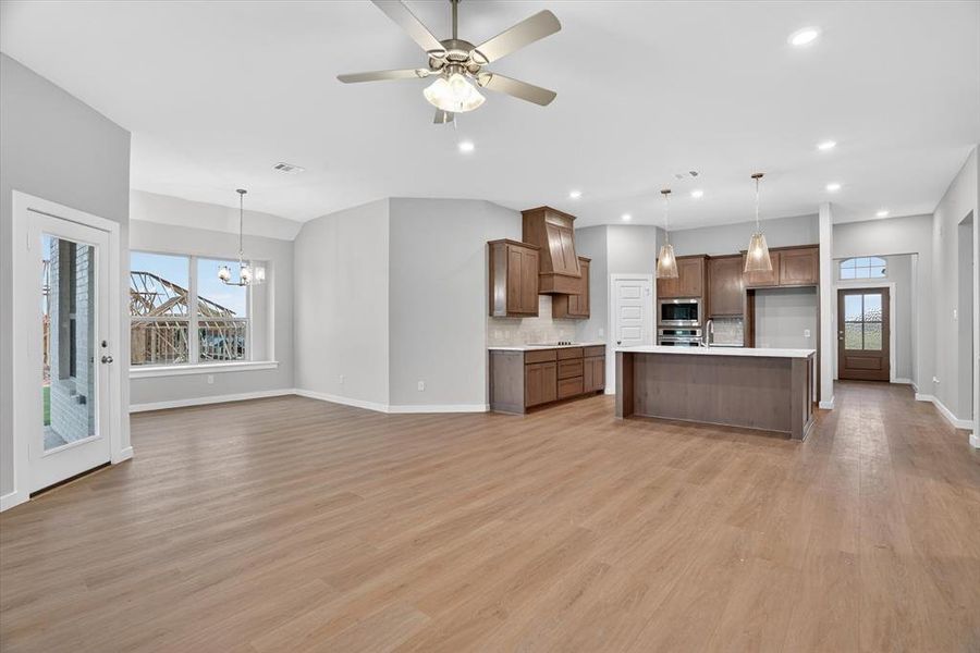 Open-concept living space featuring wood-finish flooring, recessed lighting, and a ceiling fan