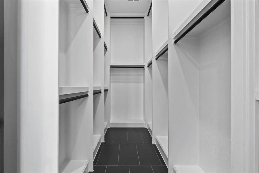 Walk in closet featuring dark tile patterned flooring Walk in closet featuring dark tile patterned flooring