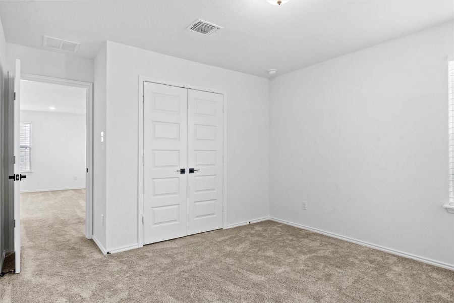Unfurnished bedroom with light colored carpet and a closet