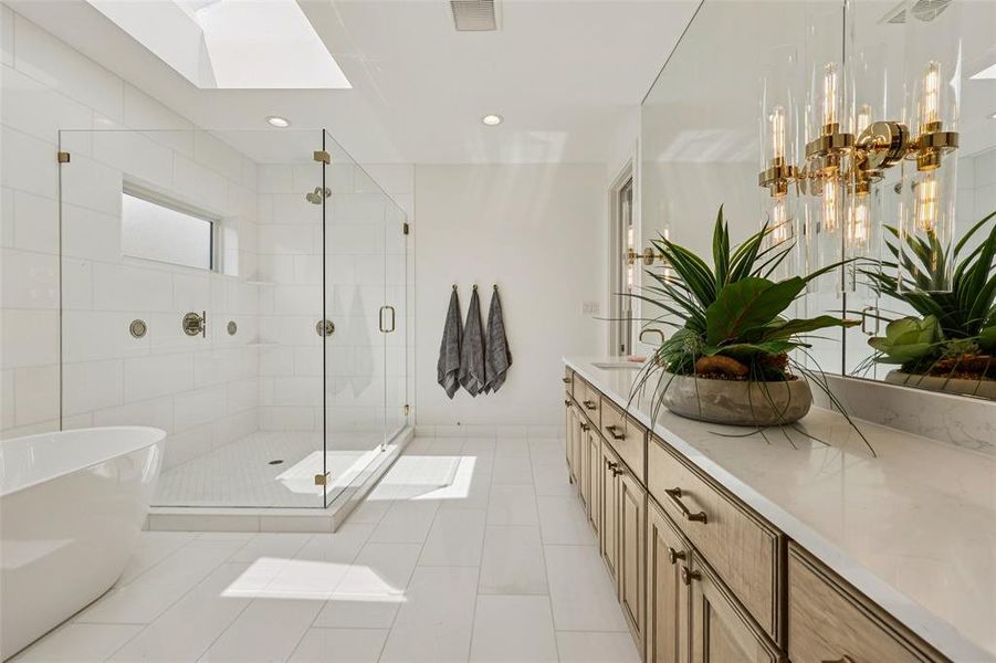 Expansive bathroom featuring a walk-in glass shower, freestanding soaking tub, and skylight