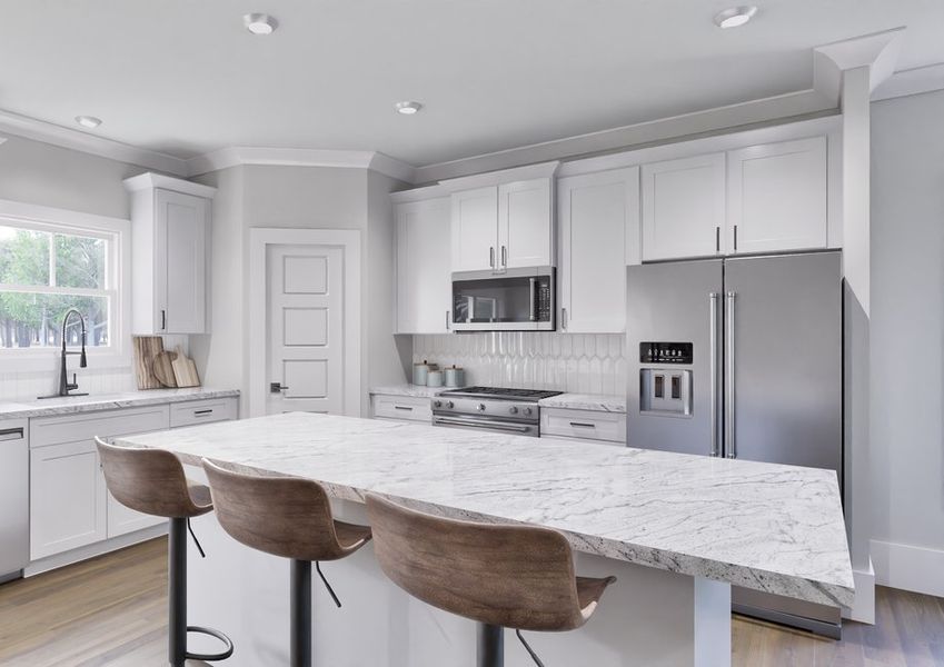 Modern kitchen in the Birch model home with stainless steel appliances and a large island.