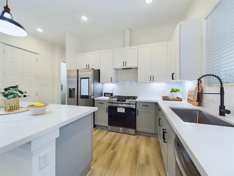 The kitchen offers  quartz countertops, stainless steel appliances, recessed lighting, and shaker cabinets and hardware with under cabinet lighting.