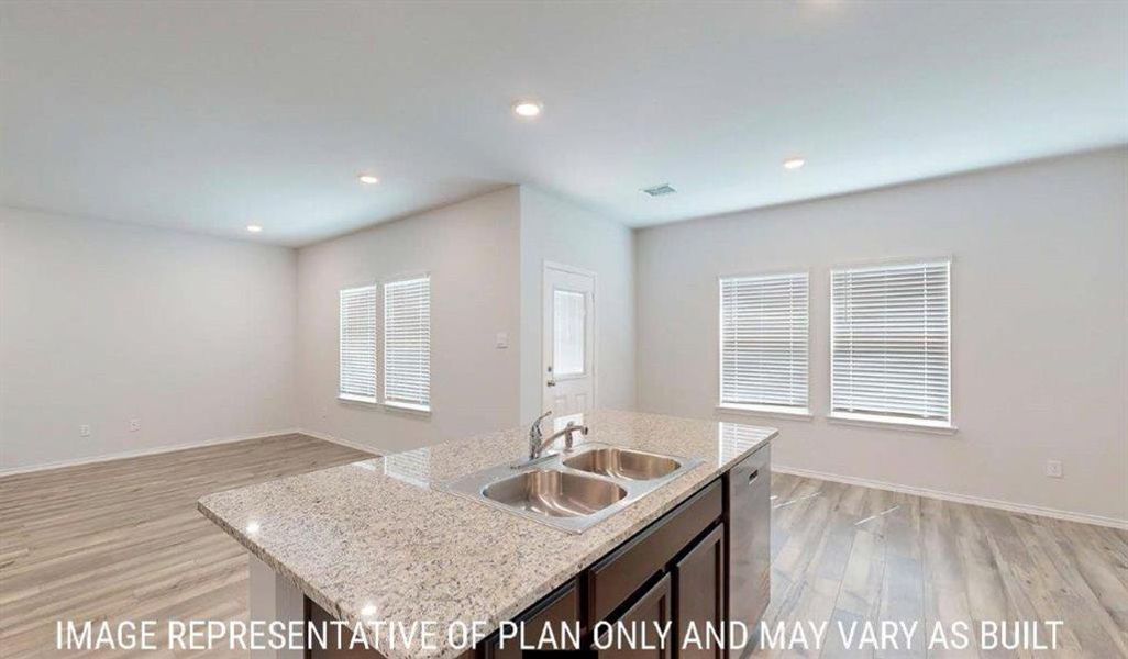 Central kitchen island featuring a double stainless steel sink and granite-style countertop Central kitchen island featuring a double stainless steel sink and granite-style countertop