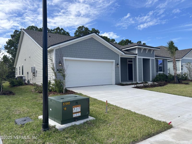 Front exterior of a new home in The Cypress Series at Reserve East, Flagler Beach, FL, highlighting curb appeal (Image 14).