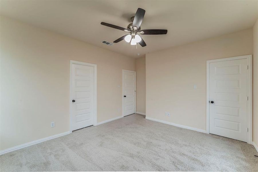 Unfurnished bedroom featuring ceiling fan and light colored carpet