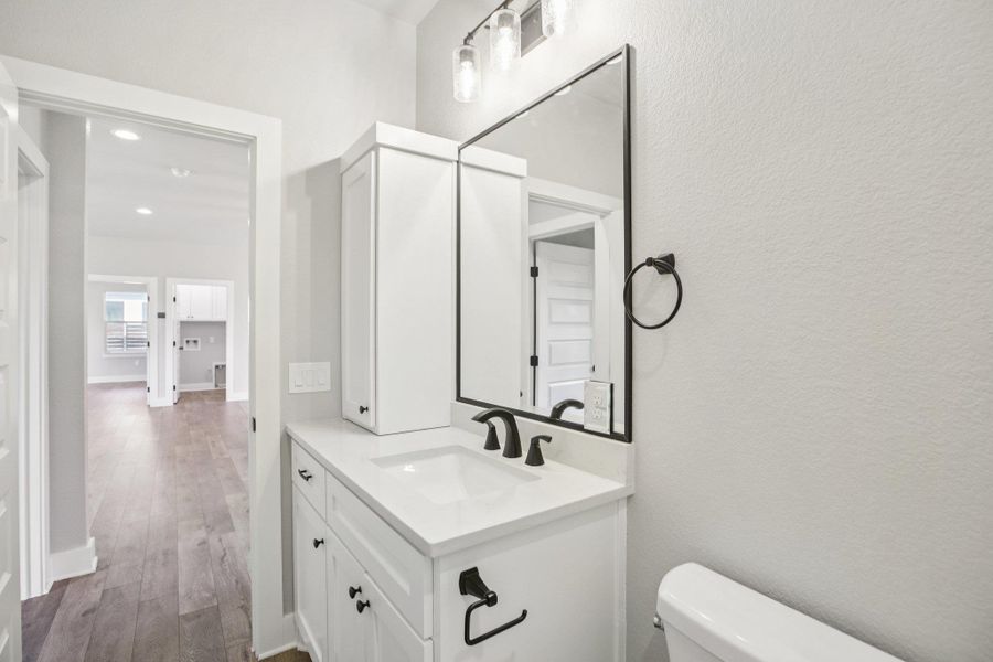 Half bathroom featuring vanity and wood finished floors