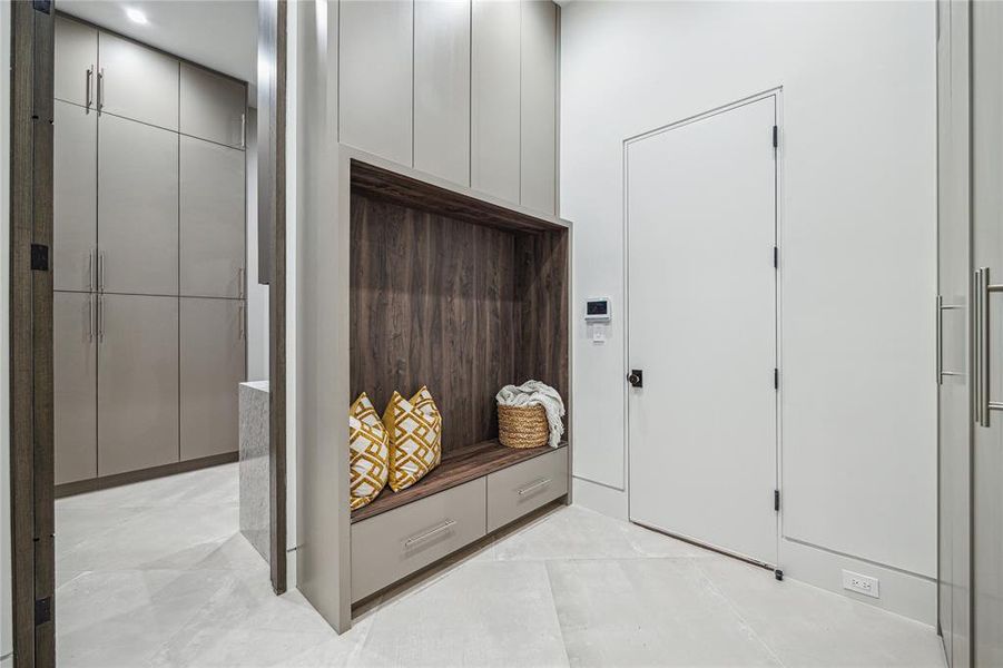 This stylish yet functional first floor mudroom provides access to the four-car showroom garage, first floor-utility toom, chef's kitchen, and back staircase.