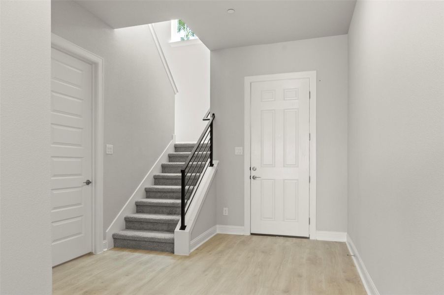 Foyer featuring light wood-style floors and stairs Foyer featuring light wood-style floors and stairs