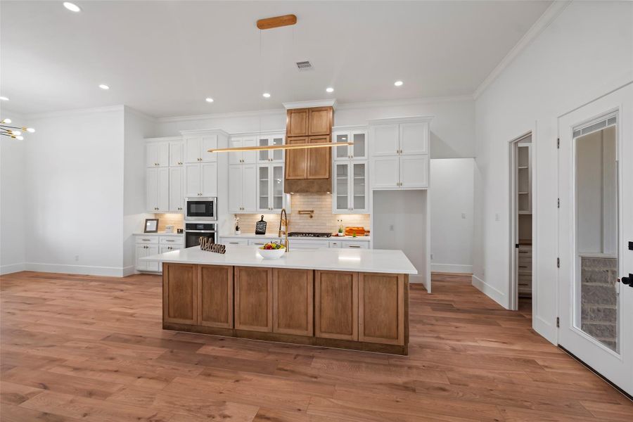 This kitchen features a spacious island, elegant cabinetry, and modern appliances, perfect for both culinary creations and gathering with loved ones.