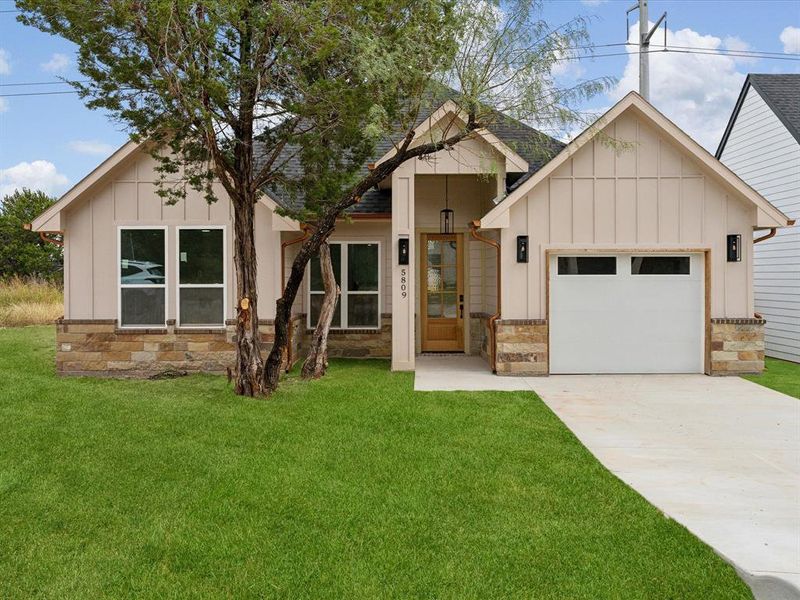 Modern farmhouse with a front yard and a garage