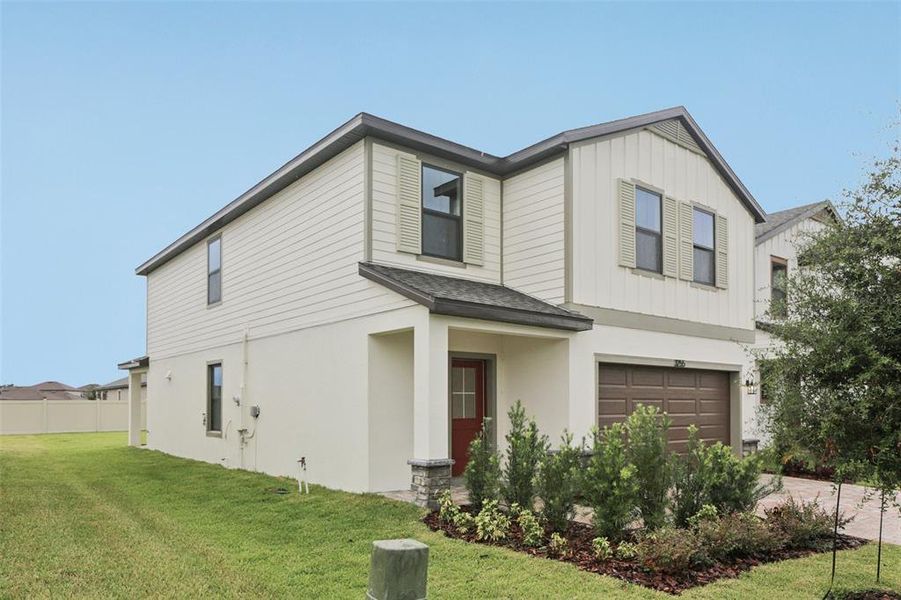 Front exterior of a new home in Grasslands West, Lakeland, FL, highlighting curb appeal (Image 1).