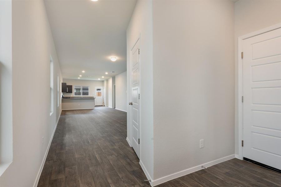 Corridor with recessed lighting, baseboards, and dark wood-style floors