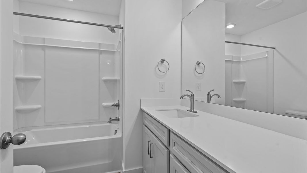 Accomplished bathroom design with sleek tile, high-quality cabinetry, and refined hardware in this secondary bathroom