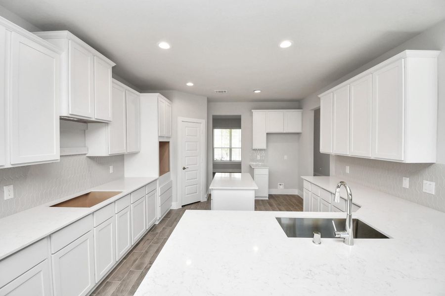 This kitchen is by far any chef’s dream! This spacious kitchen features high ceilings, white stained wood cabinets, granite countertop, SS appliances, modern tile backsplash, recessed lighting, extended counter space, and a walk-in pantry all overlooking your huge family room. Sample photo of completed home with similar floor plan. Actual colors and selections may vary.