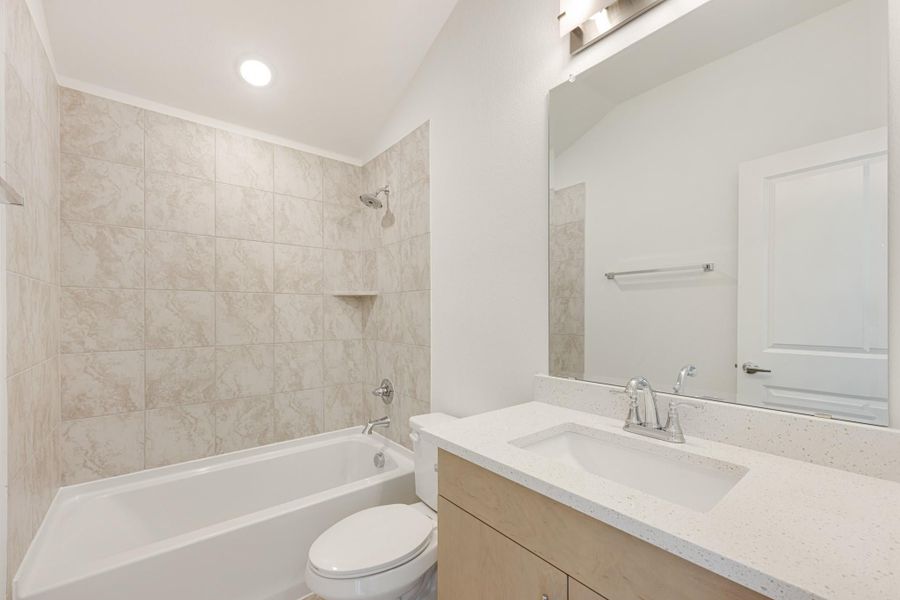 Bathroom with tub-shower combo, marble-look tile surround, single vanity with quartz countertop, and large mirror Bathroom with tub-shower combo, marble-look tile surround, single vanity with quartz countertop, and large mirror
