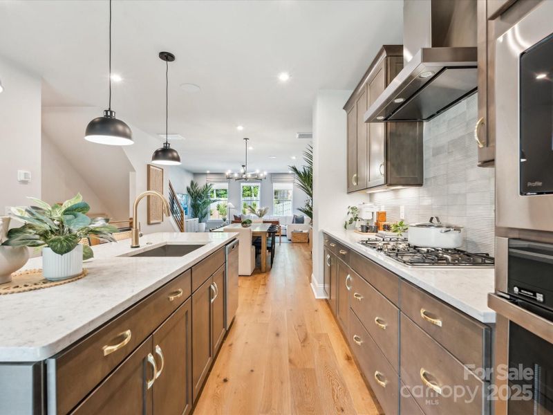 Electric Cooktop and Designer Vent Hood. *Model Photos | Actual Finishes, Structural Selections, and Orientation May Vary.