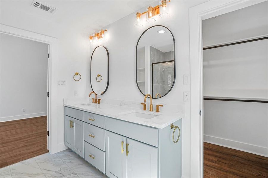 Full bath featuring a sink, visible vents, marble finish floor, and double vanity