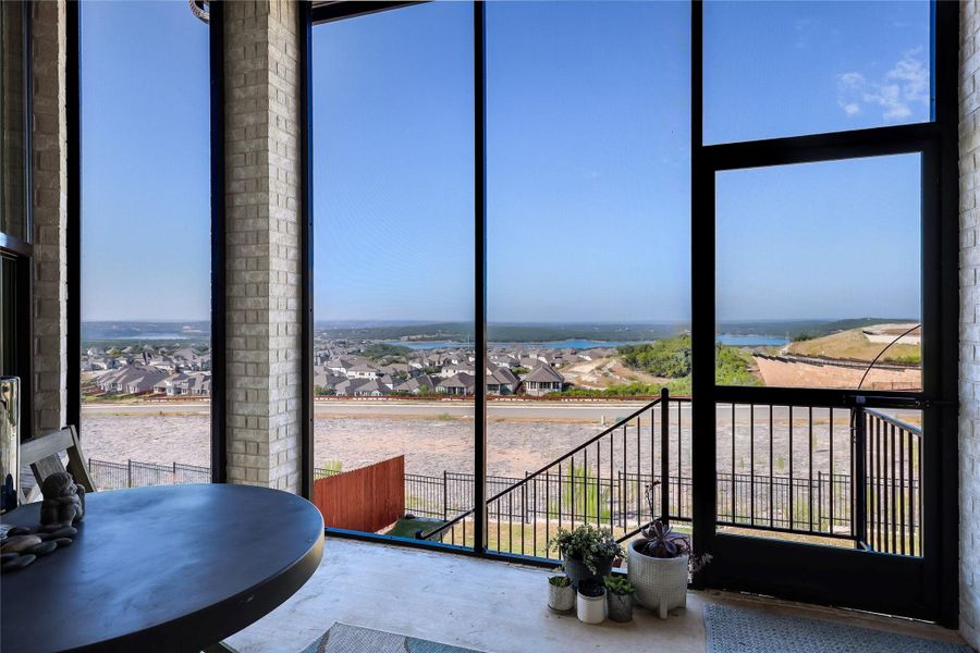Towering floor-to-ceiling windows frame sweeping neighborhood and water views from this elevated screened porch. Towering floor-to-ceiling windows frame sweeping neighborhood and water views from this elevated screened porch.
