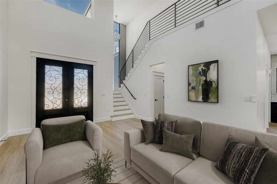 A grand staircase lined with wrought iron railings leads to the second floor. (virtually staged photo)