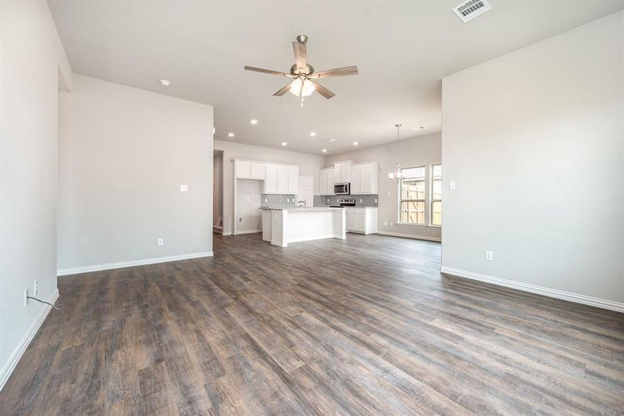 Unfurnished living room with ceiling fan, dark hardwood / wood-style flooring, and sink