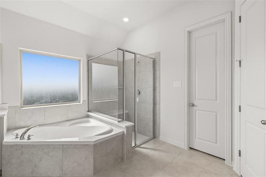 Bathroom with a shower stall, a garden tub, light tile patterned flooring, recessed lighting, and vaulted ceiling Bathroom with a shower stall, a garden tub, light tile patterned flooring, recessed lighting, and vaulted ceiling