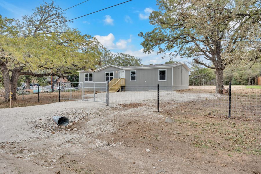 View of front of home featuring a fenced front yard and a gate