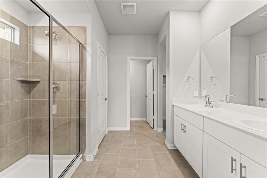 Bathroom featuring tile patterned flooring, vanity, and an enclosed shower