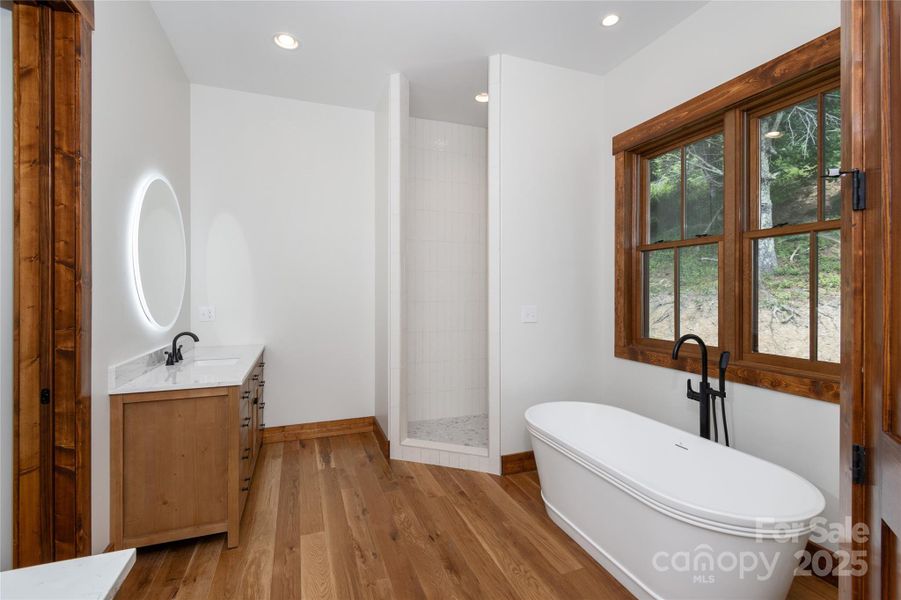 Main floor primary suite with incredible mountain views, access to porch & 2 walk-in closets. Primary bathroom with double vanities & backlit mirrors, soaking bathtub, shower & water closet.
