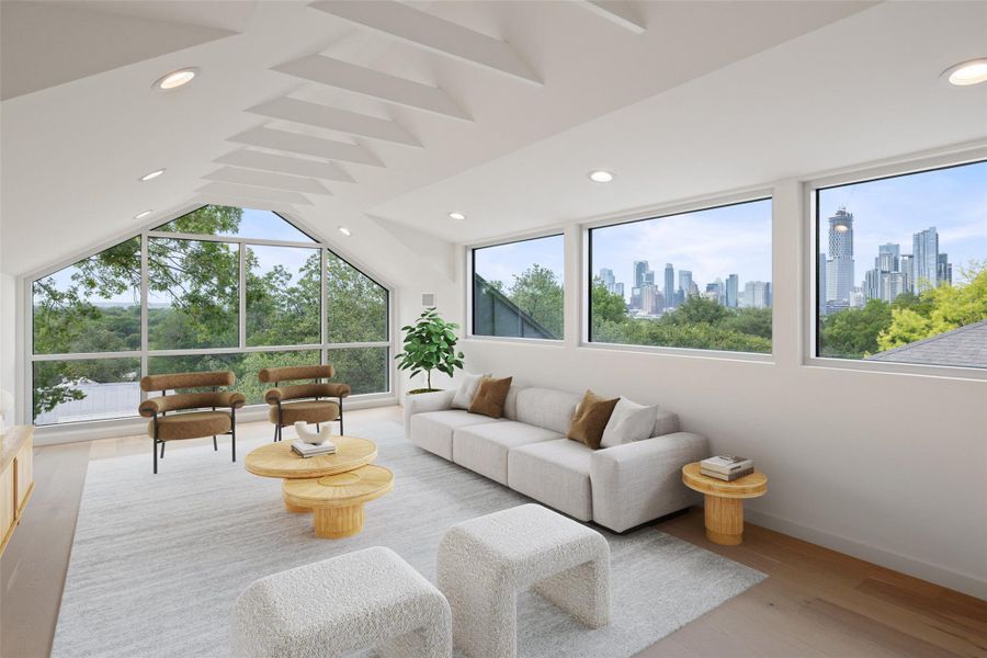 Living area with light wood-type flooring, vaulted ceiling, recessed lighting, and a view of skyline Living area with light wood-type flooring, vaulted ceiling, recessed lighting, and a view of skyline