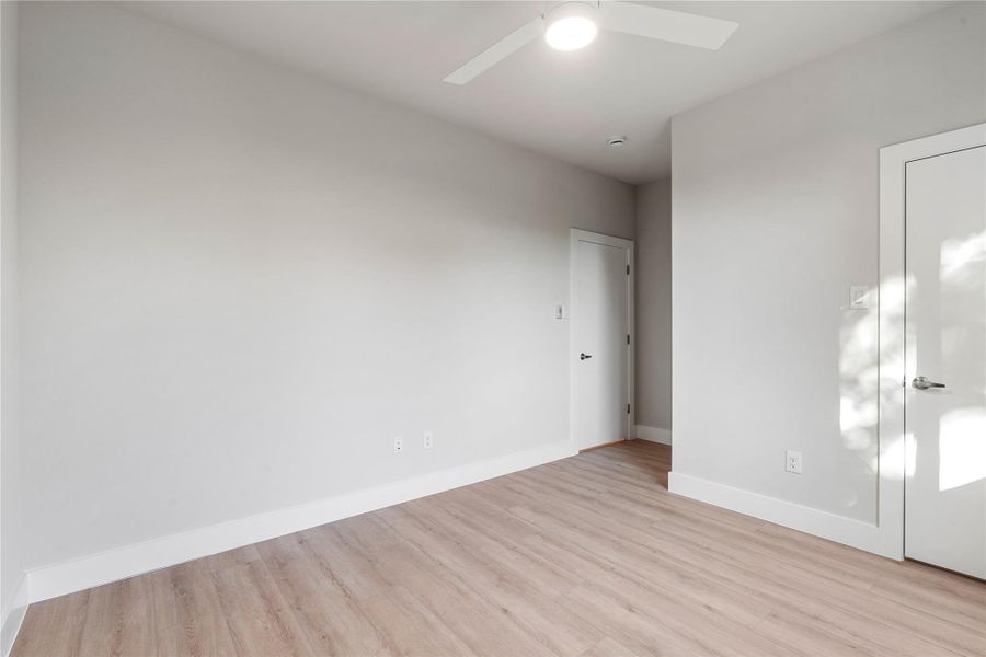 Secondary bedroom with tall windows, ceiling fan and clean architectural lines. Secondary bedroom with tall windows, ceiling fan and clean architectural lines.