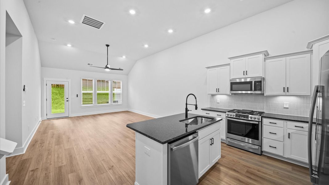 Tasteful kitchen with a streamlined island and modern finishes in a first-class DRB Homes design Tasteful kitchen with a streamlined island and modern finishes in a first-class DRB Homes design