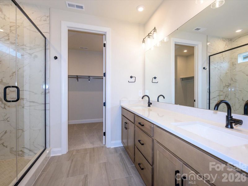 En Suite Primary Bath with Dual Vanity and Loads of Storage Leading to Walk-In Closet.