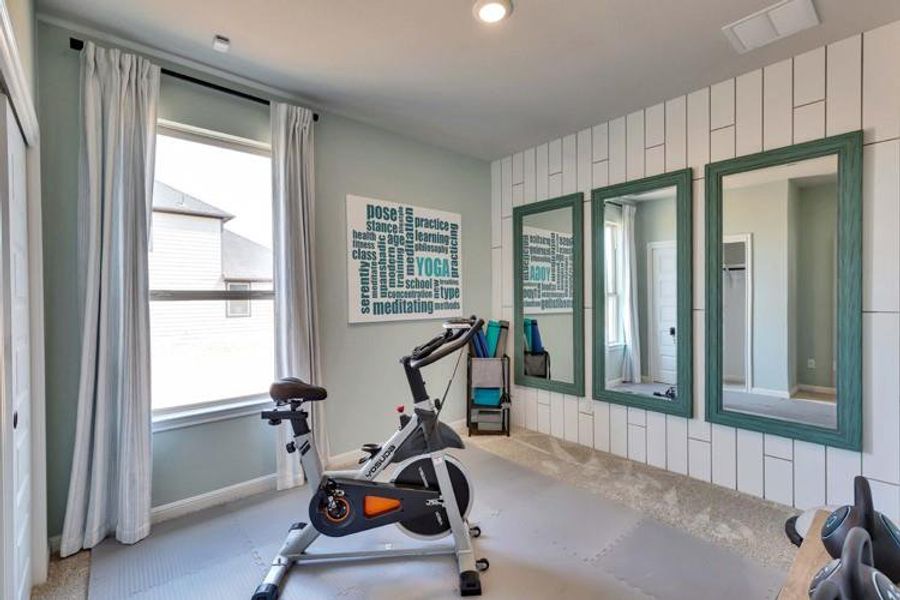 Workout area featuring carpet, visible vents, wood walls, and baseboards