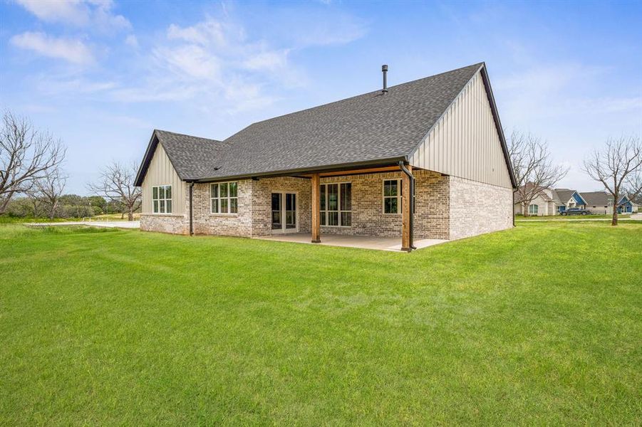 Rear view of property with a yard and a patio area