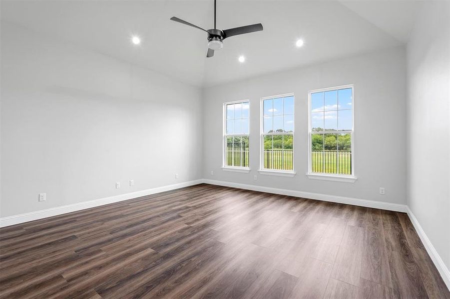 Spare room featuring ceiling fan, dark hardwood / wood-style flooring, and vaulted ceiling