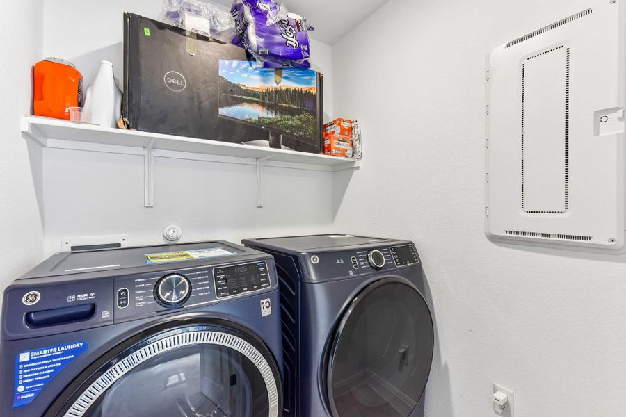 Functional laundry space featuring modern appliances and convenient shelving.