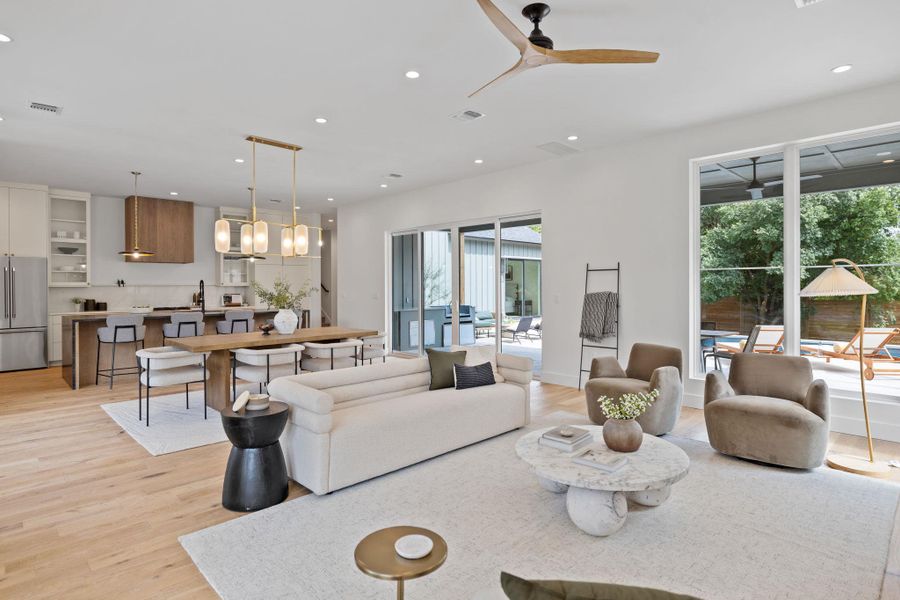 Living area with recessed lighting, light wood-style floors, and a ceiling fan Living area with recessed lighting, light wood-style floors, and a ceiling fan